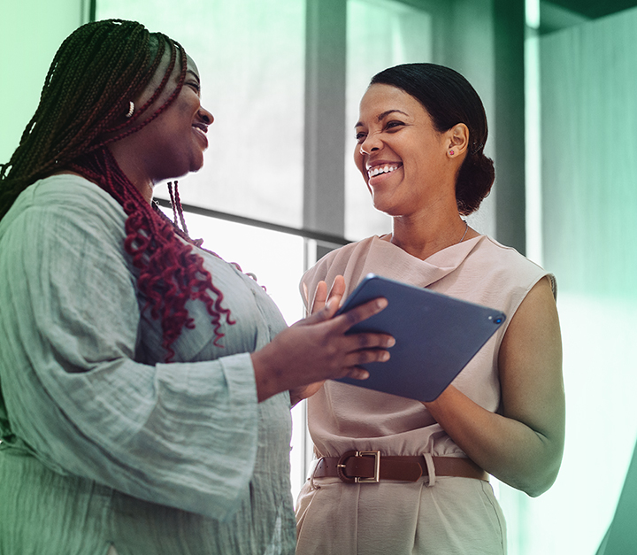 two healthcare workers smiling and talking together
