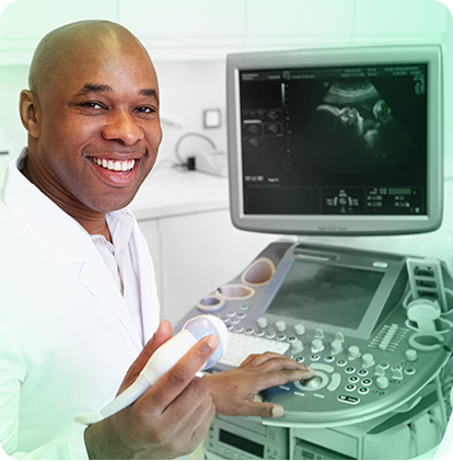 a male sonographer smiling in front of a sonography machine